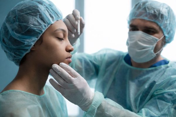 Doctor examines patient to perform FaceTite.